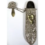 A hall marked silver spectacles case with embossed scrolling floral decoration, with chain and hook,