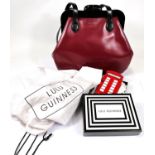 Lulu Guinness: A dark red handbag with black straps & clasp, black & white stripe fabric lining,