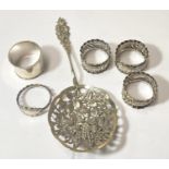 A Continental white metal berry spoon with pierced decoration; 4 hallmarked silver napkin rings; a