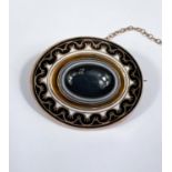 A Victorian yellow metal oval mourning brooch set with  a bull's eye agate central stone, black &