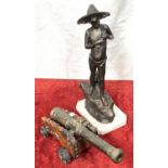 A reproduction miniature cannon, length 34cm; a spelter figure:  boy hugging a fish (a.f.), height
