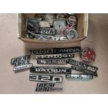 A selection of vintage car badges, including Toyota, Fiat AA etc