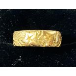 An 18 carat gold wedding ring with embossed floral pattern, 5.8gm