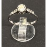 A white metal ring stamped 'Platinum' set diamond solitaire with 3 smaller diamonds to each