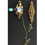 An Art Nouveau yellow metal brooch with central clear opalescent cabochon stone with smaller opal