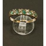 A gold dress ring, hallmarks worn, set with 5 emerald coloured stones and smaller diamonds around,