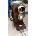 A wooden and brass vintage wall phone