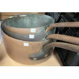 A graduated group of 3 early 19th century country house kitchen copper saucepans , steel handles,