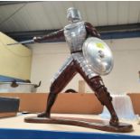 A resin and aluminium sculpture depicting a swordsman in armour, ht. 50cm