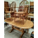 An Ercol style dining suite comprising oval extending table and 6 (4 + 2) wheel back chairs