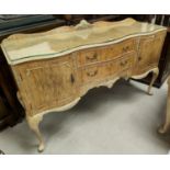 A burr walnut dining table in the Epstein manner with rounded rectangular edges, carved lip and