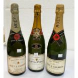 Two bottles of Moet & Chandon champagne; a bottle of Laurent Perrier champagne