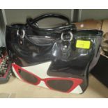 Lulu Guinness, a black patent handbag with red patent sun glasses design on a cream fabric