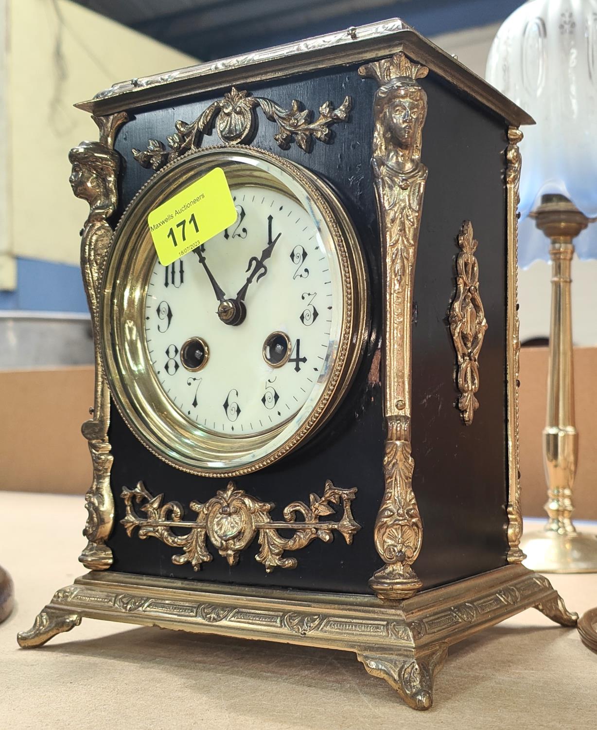 An ornate 19th century gilt metal and black mantle clock with striking French drum movement, ht.