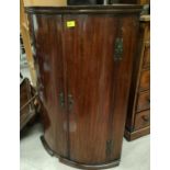 A Georgian mahogany corner cupboard with bow front enclosed by 2 doors