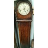 A 1930's oak granddaughter clock with arch top and barley twist side columns and chiming movement,