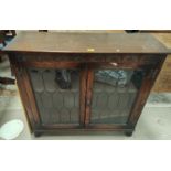 An oak bookcase with leaded glass door