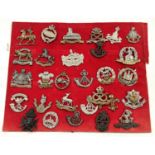 A selection of cap badges including Manchester, Leicester, Gloucestershire Regiments; a book The