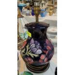 A Moorcroft large, Clematis lamp with blue ground and wooden base, ht. 36cm
