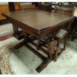 A 1930's oak dining suite in the Jacobean style comprising draw leaf table on carved bulbous legs