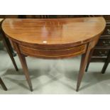 A Sheraton style inlaid mahogany card table, the demi-lune fold over top with baize lining, on