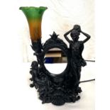A bronzed table lamp decorated with girls, with coloured shade and mirror back