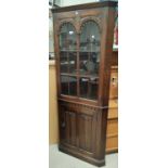 A good quality oak full height corner cupboard with panelled door bellow and glazed door above; An