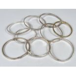 Nine white metal bangles stamped 925, some with cut and etched decoration, gross 80gms.