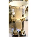 A pair of large brass table lamps with Corinthian columns, with shades