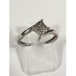 A white gold dress ring with small diamonds in square setting and cross over design,1.9gm, size L