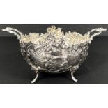 A rococo period 2 handled bowl with extensive repousse decoration depicting cherubs in landscapes,