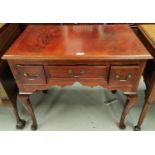 An inlaid mahogany reproduction lowboy with 3 frieze drawers, on cabriole legs