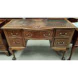 A mid 20th century mahogany kneehole desk in the Georgian style with gadrooned rim and 5 drawers, on