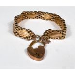 A yellow metal gate bracelet st. 9ct with 9ct hallmarked gold heart locket, 19.8gm