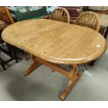 An Ercol style dining suite comprising oval extending table and 6 (4 + 2) wheel back chairs