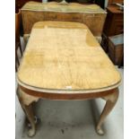 A burr walnut dining table in the Epstein manner with rounded rectangular edges, carved lip and
