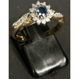 An 18 carat hallmarked gold cluster ring set sapphire and diamonds, length of sapphire 4mm approx,