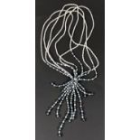 A freshwater pearl multi strand necklace with mix of grey tasseled drop to front