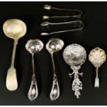 A continental white metal spoon with farm and windmill decoration, silver plated ladles and tongs