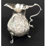 A mid Georgian silver cream jug of baluster form with repousse decoration, London  1755, maker S.M.,