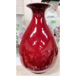 A Chinese Oxblood glazed vase with bulbous body, flared rim, associated stand, ht. 35cm incised mark