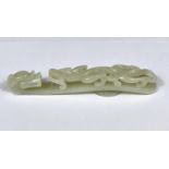 A large Chinese jade coloured hardstone belt buckle with dragon decoration length 13cm