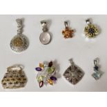 Eight silver pendants of various designs, flowers etc set with a variety of coloured stones