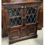 An oak side cabinet with leaded glass double doors