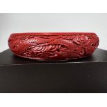 A Chinese vintage cinnabar bangle carved with dragons in foliage, internal diameter 6.5cm, depth 1.