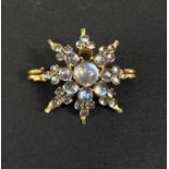 A yellow metal star brooch set graduated moonstones, stamped '9ct', 5.7gm (1 stone missing)