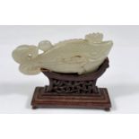 A Chinese jade coloured hardstone carving of a fish on associated stand, length 9cm