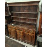 An 18th century Country made Welsh dresser with 3 height delft rack over 3 frieze drawers, 2 side