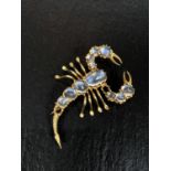 An early 20th century yellow metal brooch in the form of a scorpion with graduated moonstones (2
