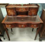 A reproduction figured mahogany writing desk by "Reprodux" having raised back with cupboards and